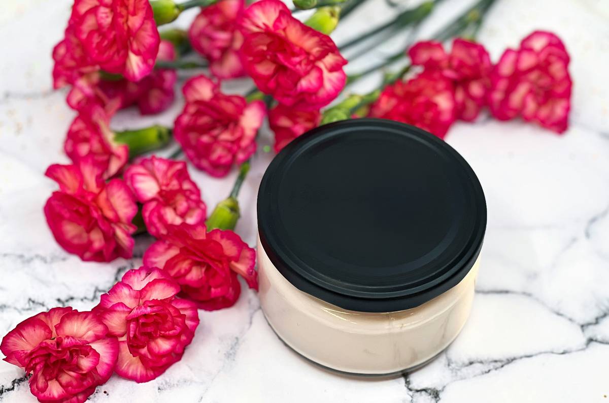 Plant-Based Care applied to skin with botanical extracts in glass jars